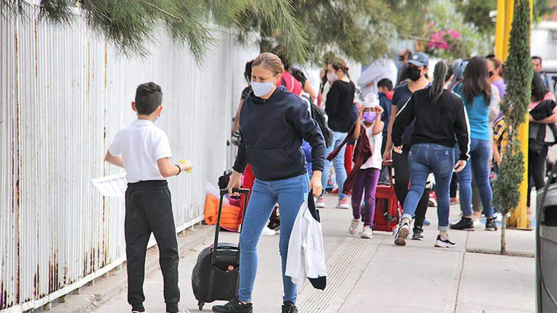 alumnos y padres fuera de una escuela